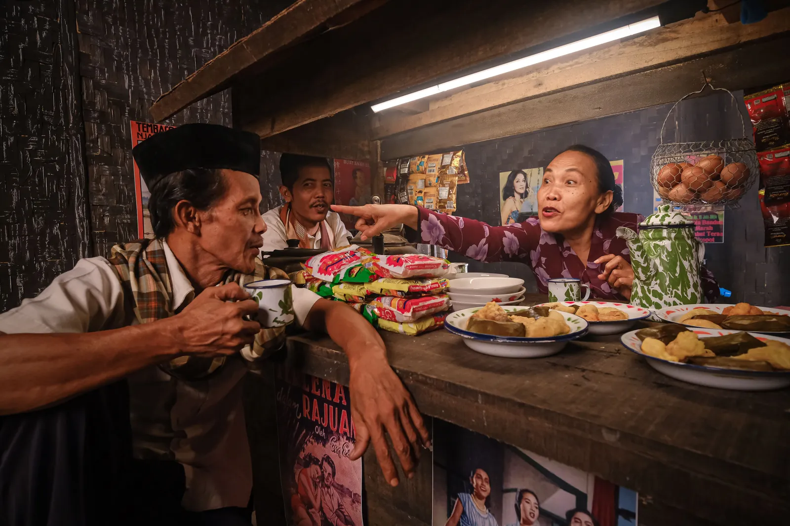 Customers eating at the counter inside a small family run warung in Indonesia