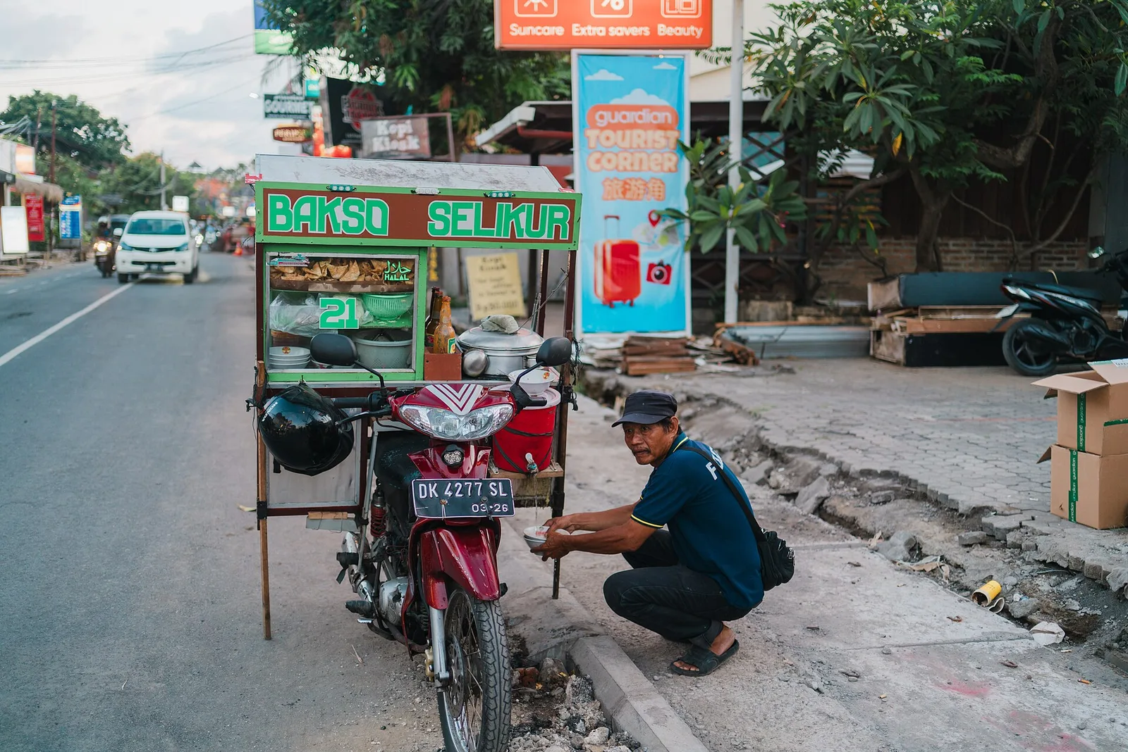A row of scooters parked outside a colourful warung on a Bali street