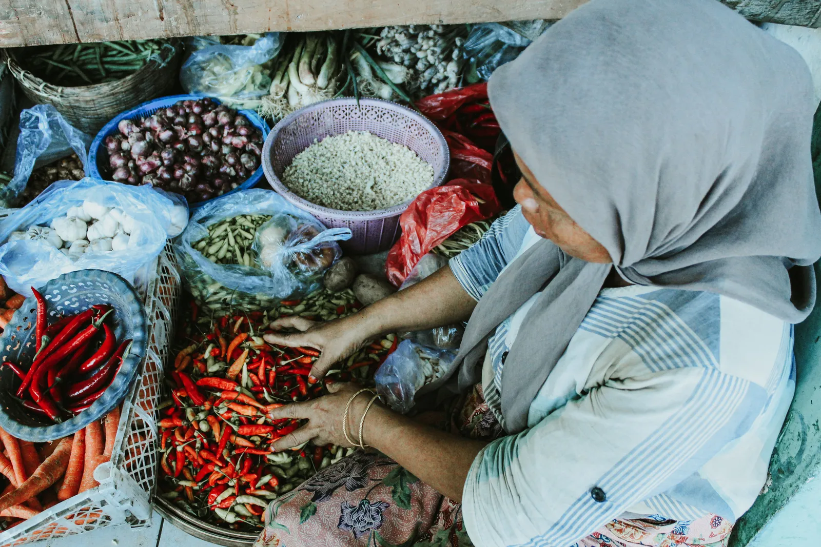 Trays of fresh chillies, shallots, galangal and turmeric on a market stall in Bali, Indonesia