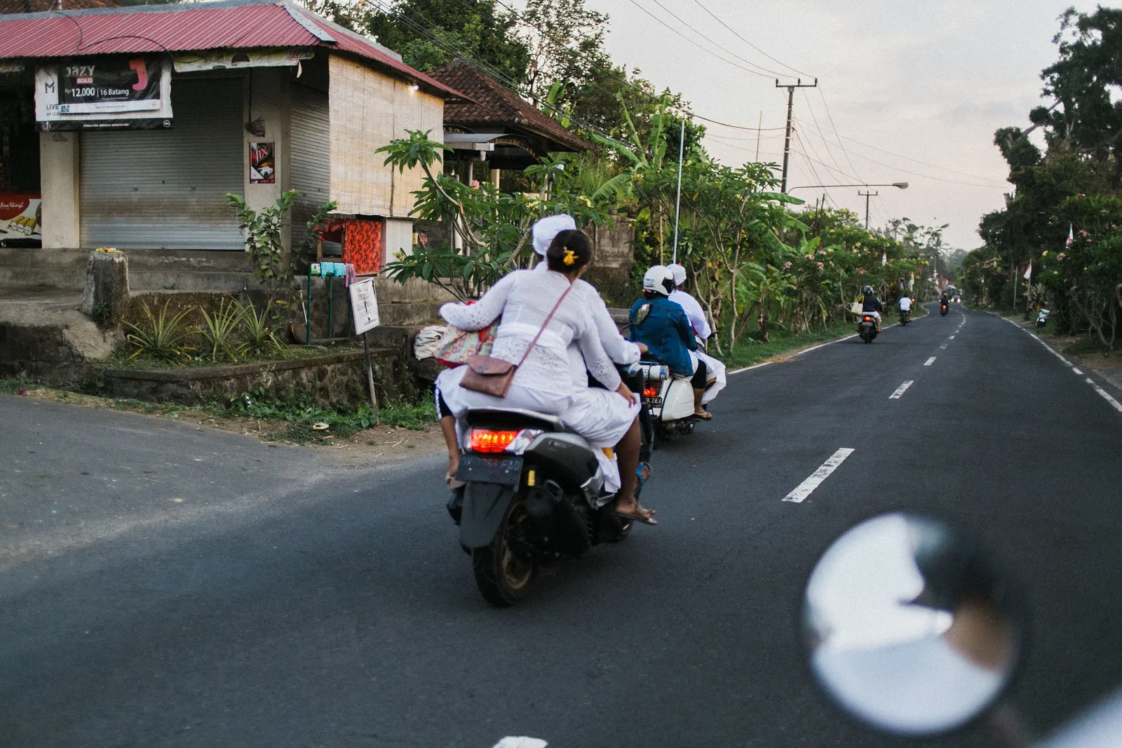A busy narrow road with scooters and cafes in Canggu, southern Bali, Indonesia