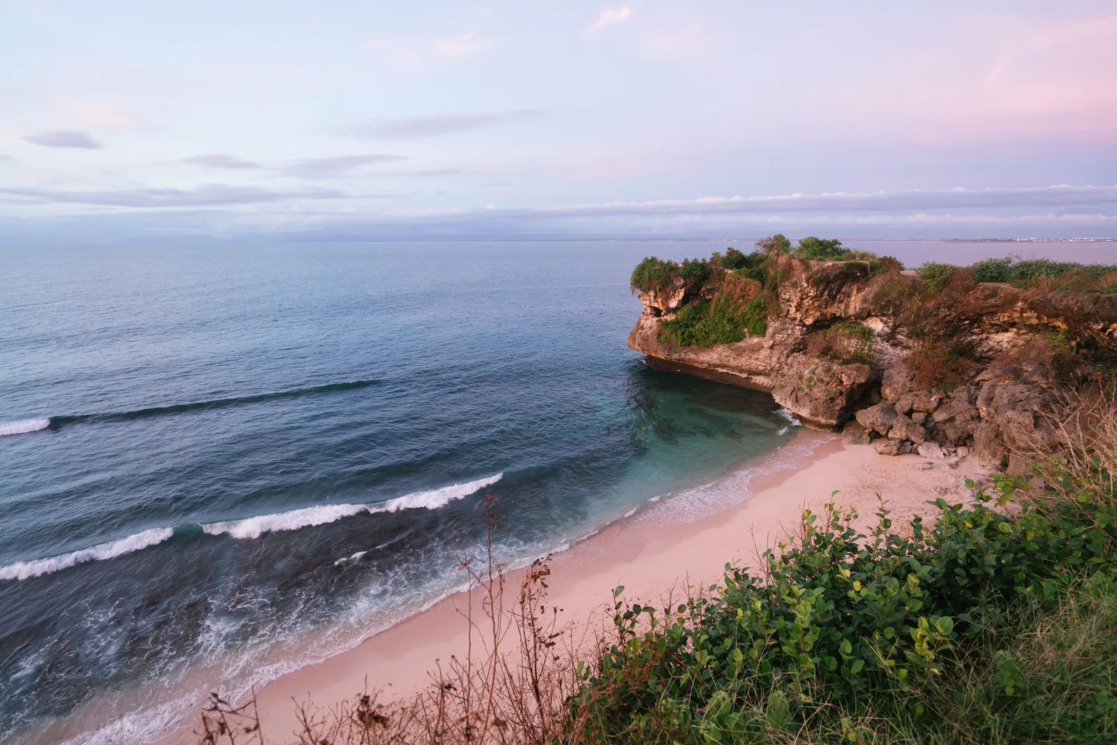 A beach below rocky cliffs on the Bukit peninsula, Bali, Indonesia