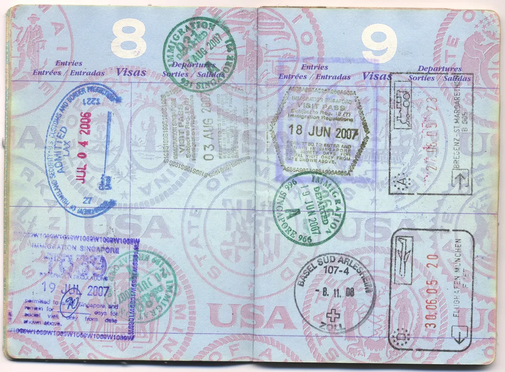 A passport page filled with entry and exit immigration stamps from several countries