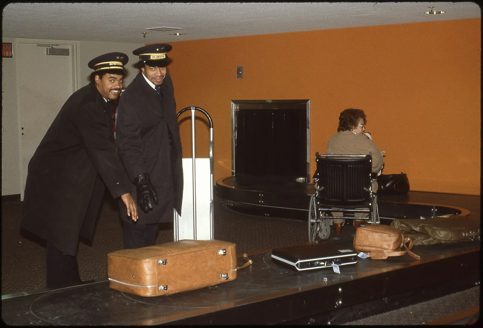 Suitcases circling an airport baggage claim carousel in an arrivals hall