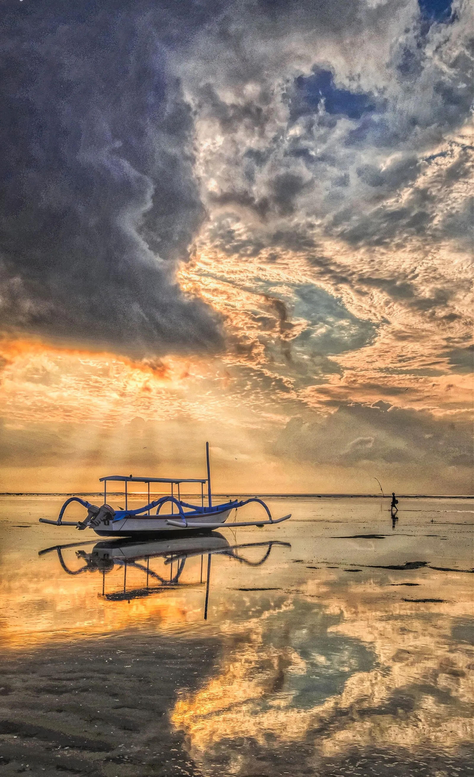 Traditional outrigger boats on calm water at Sanur beach, Bali, on a cloudy morning
