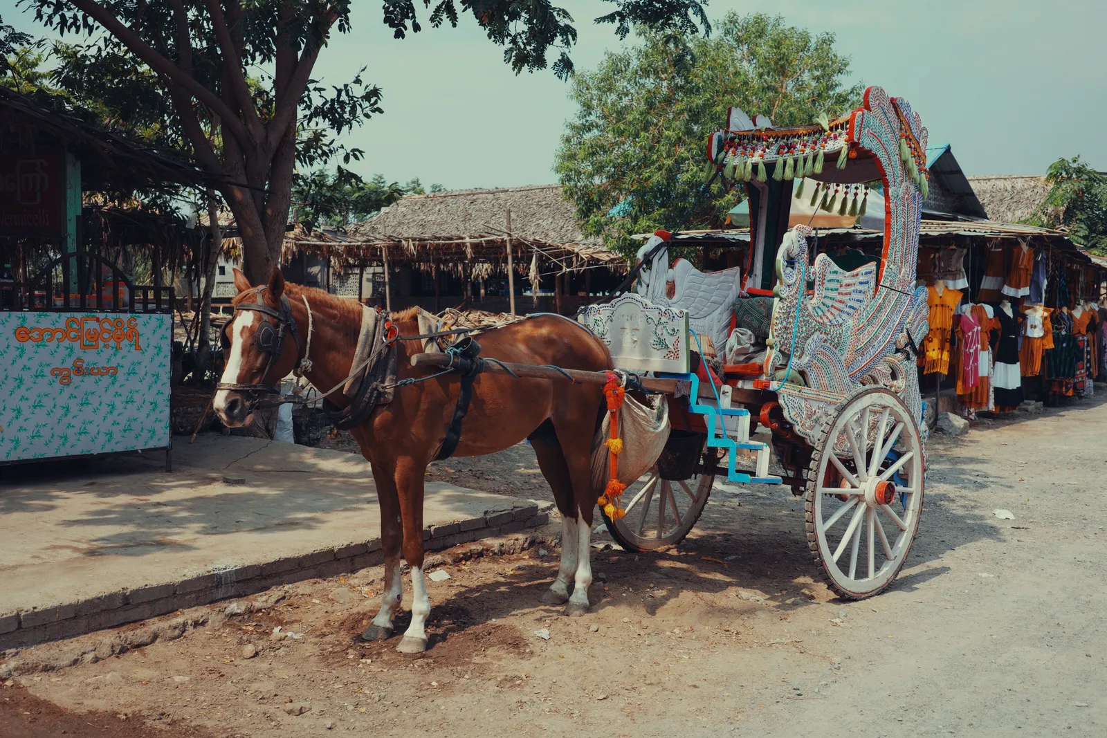 A wooden horse-drawn cidomo cart on a sandy path on one of the Gili Islands near Lombok