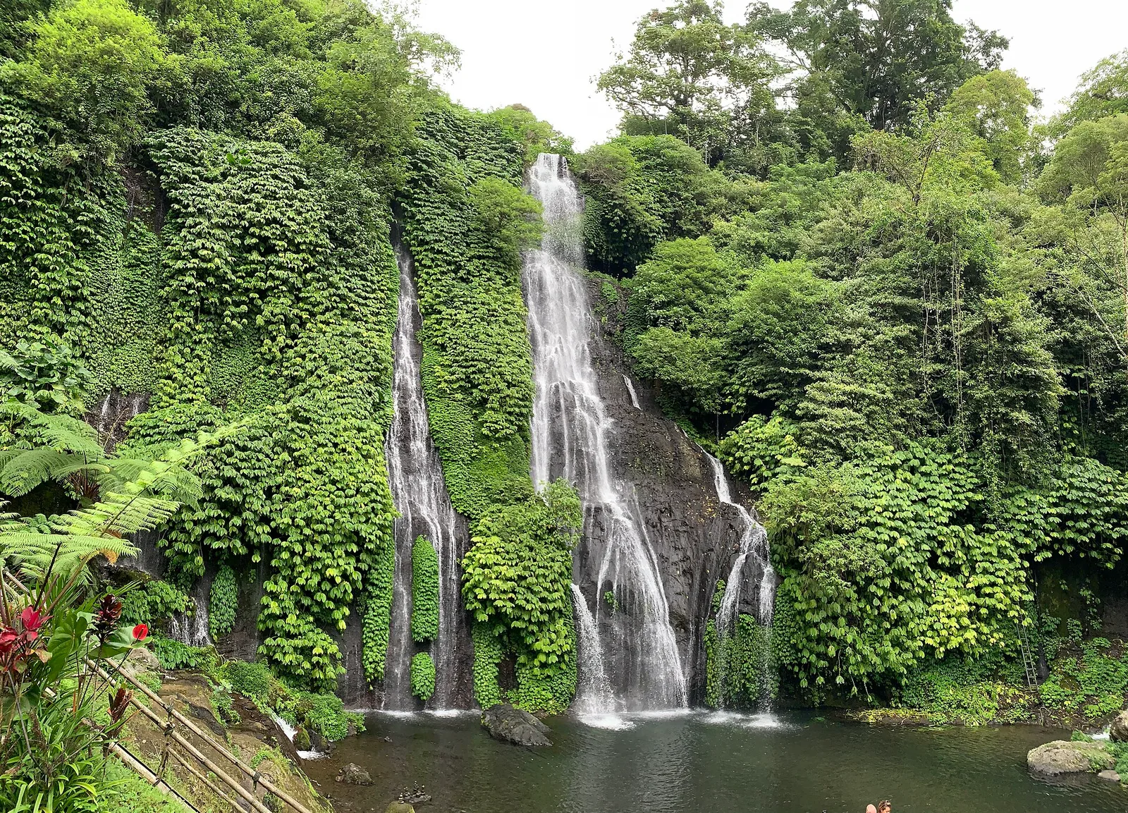 A waterfall dropping through dense green forest near Munduk, Bali