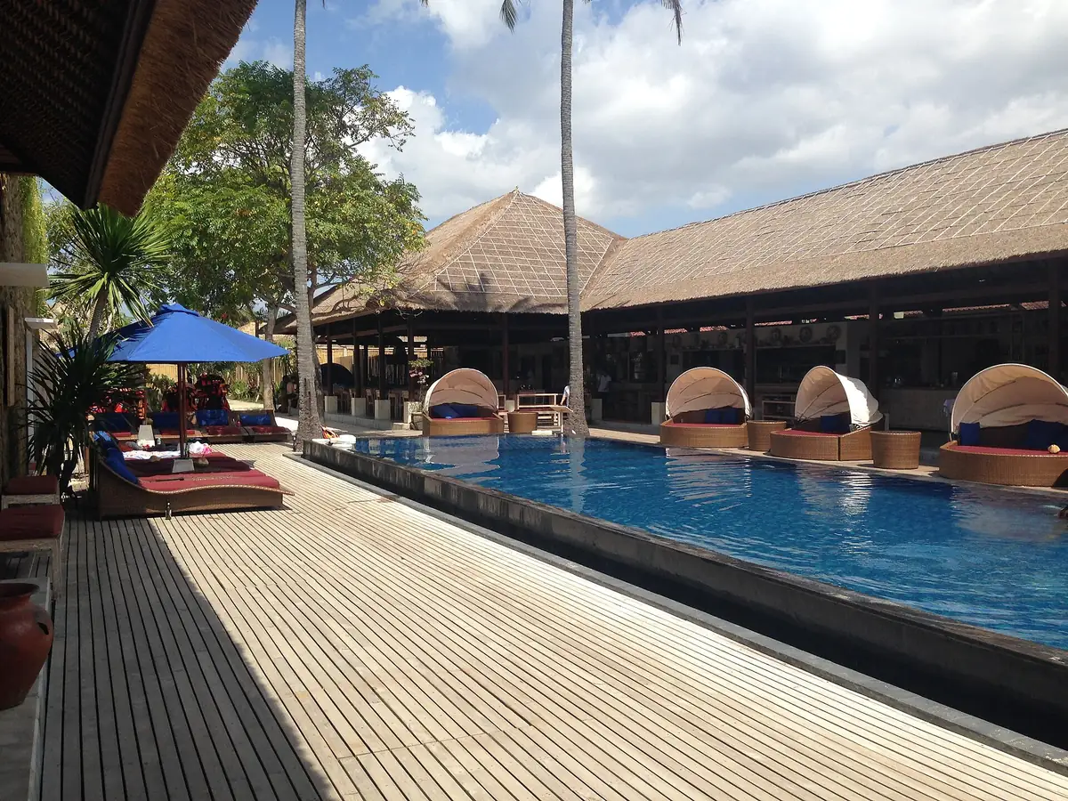 A pool and a thatched pavilion beside the shore
