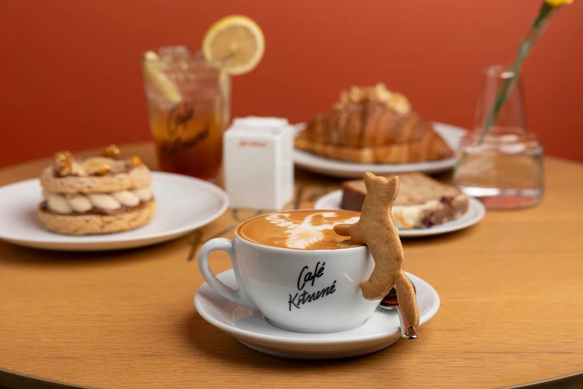 A cappuccino and pastries on a wooden table