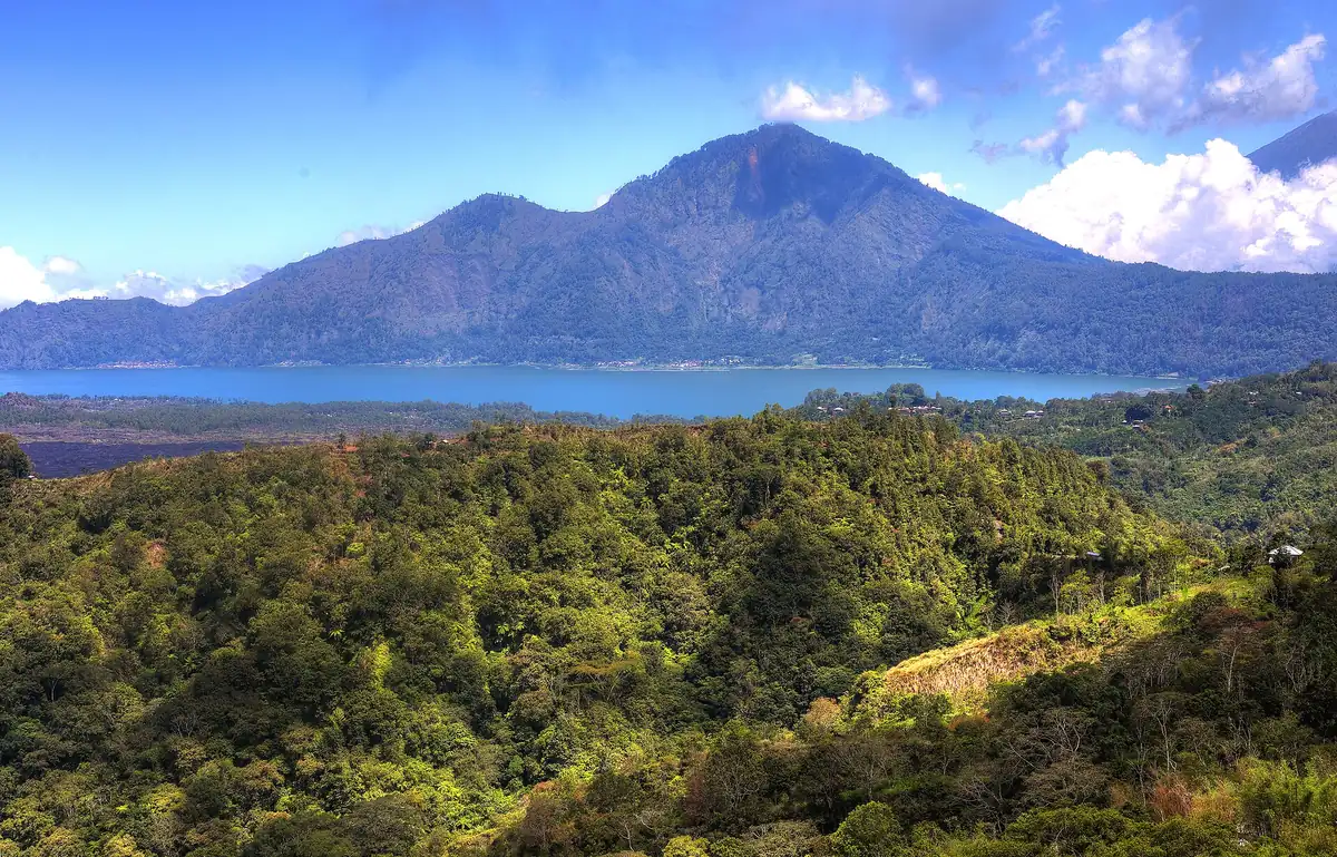 A volcano and a lake among forested slopes