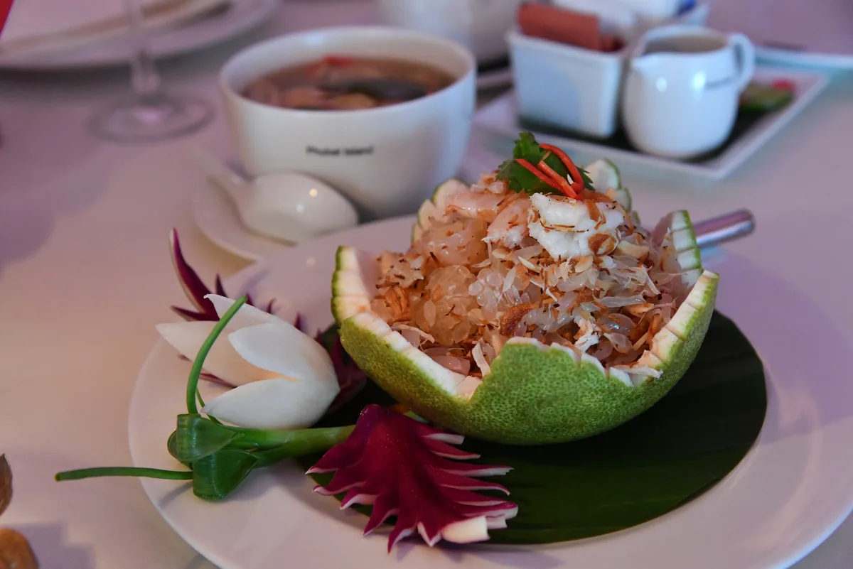 A salad served inside a carved pomelo shell