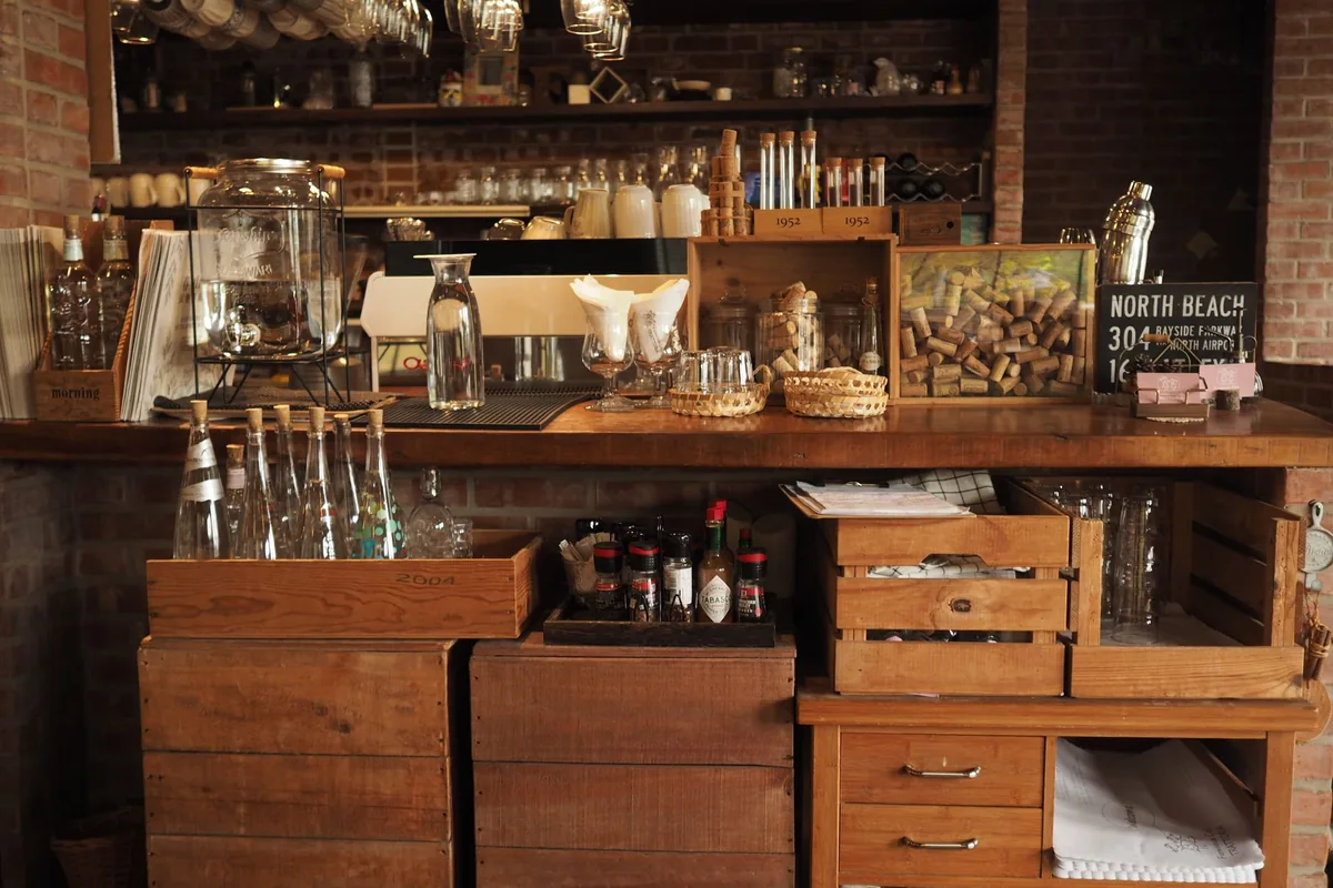 A wooden bar counter with crates and glassware