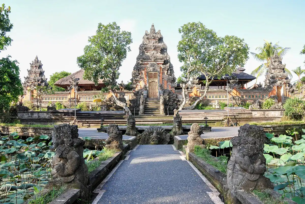 A Balinese temple gate at the end of a path above a lotus pond