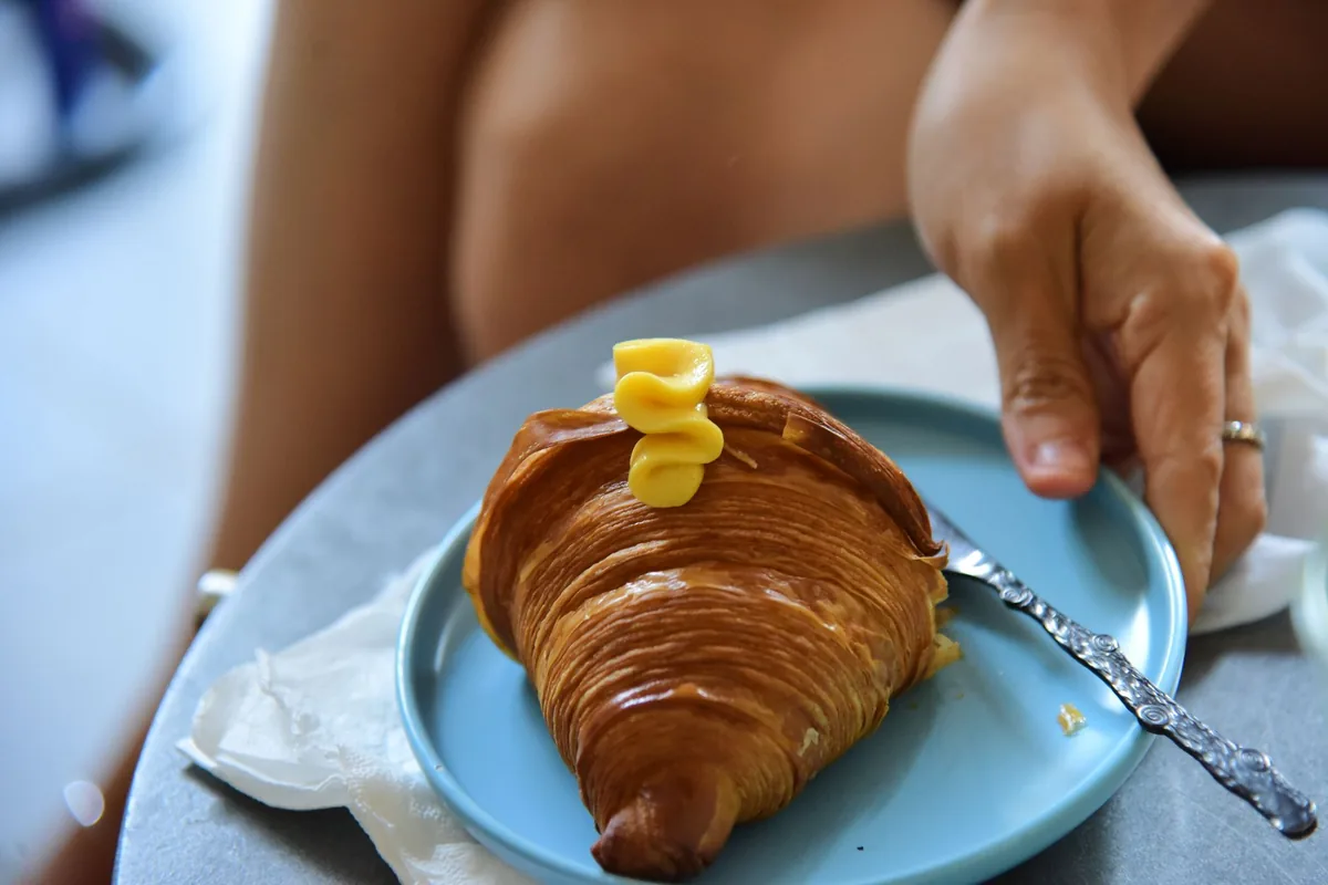 A fresh croissant on a pale blue plate