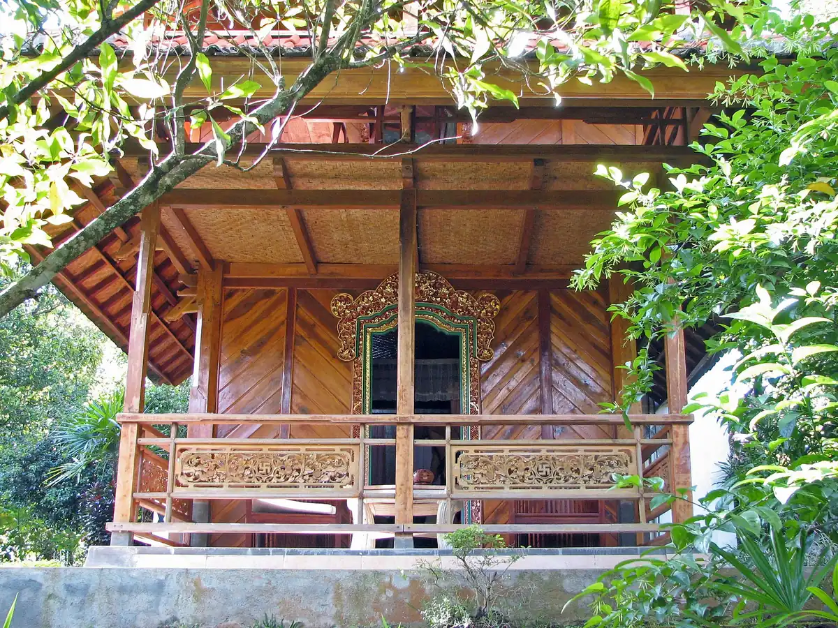 A traditional wooden pavilion among tropical greenery