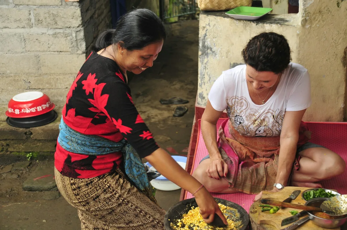 Two women preparing Balinese food on a mat
