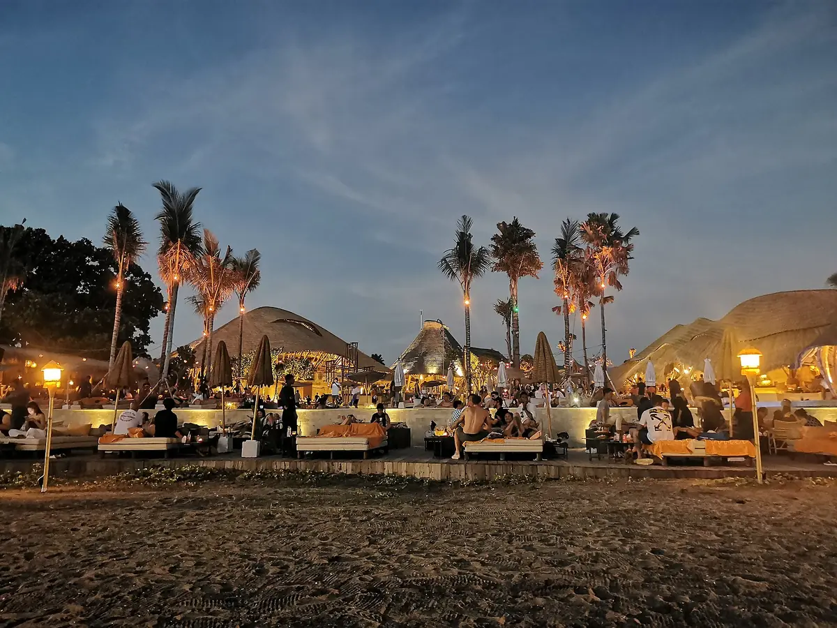 A lit beach bar on the sand in the evening