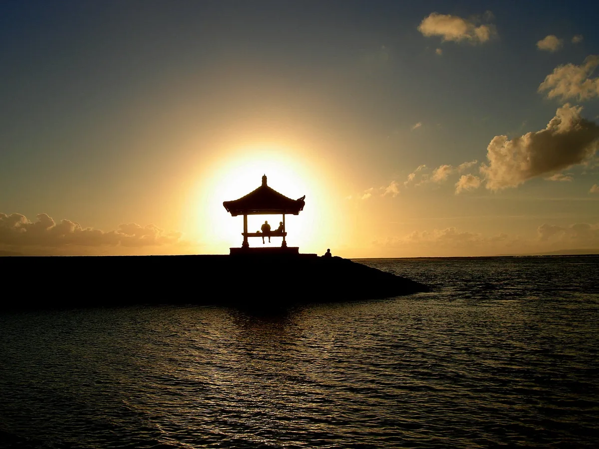 A short jetty with a covered pavilion facing the sunrise