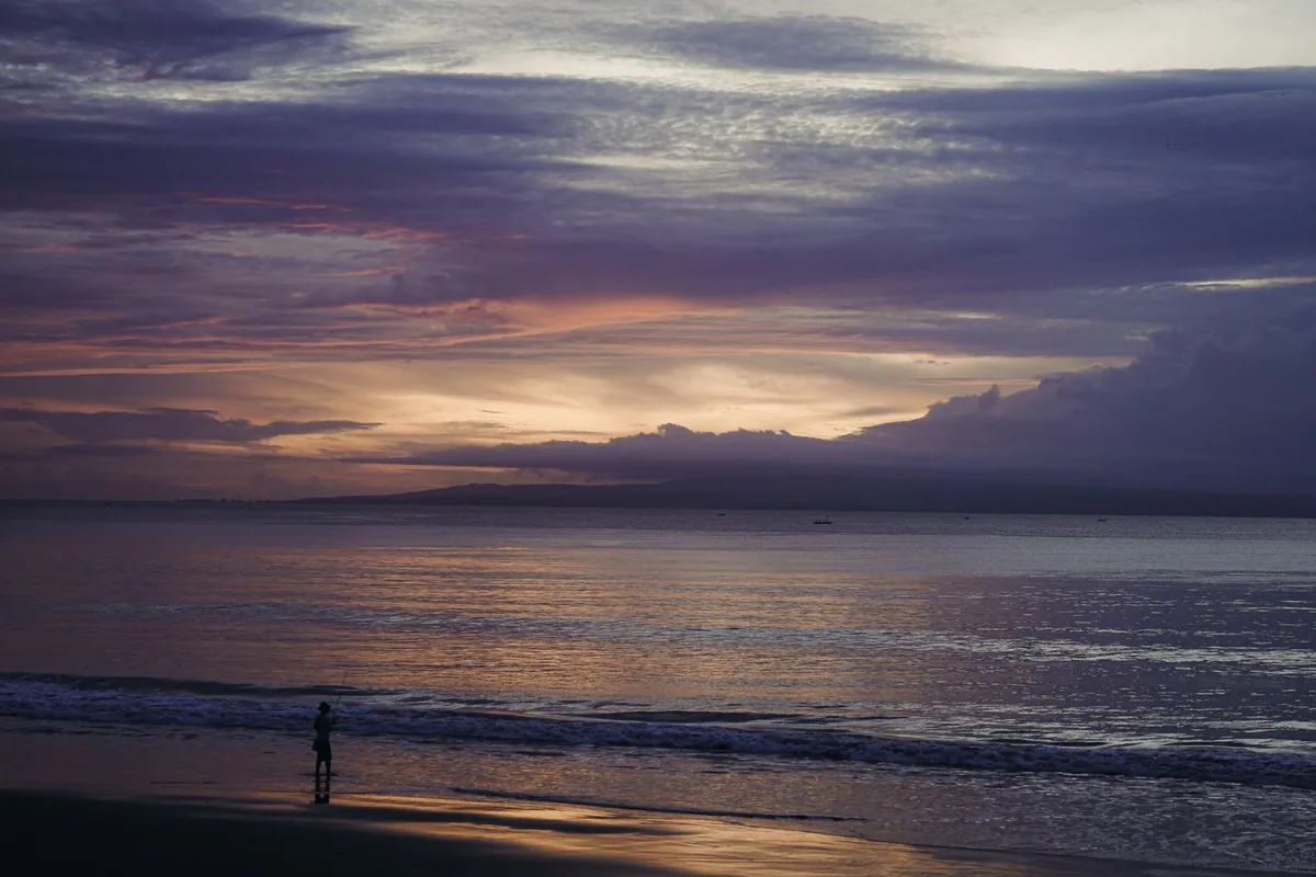 Calm sea at sunset under clouds