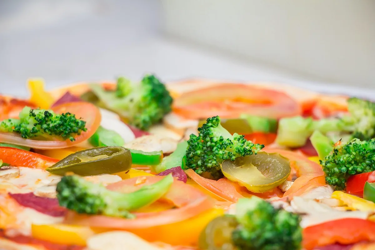 A close up of a vegetable pizza