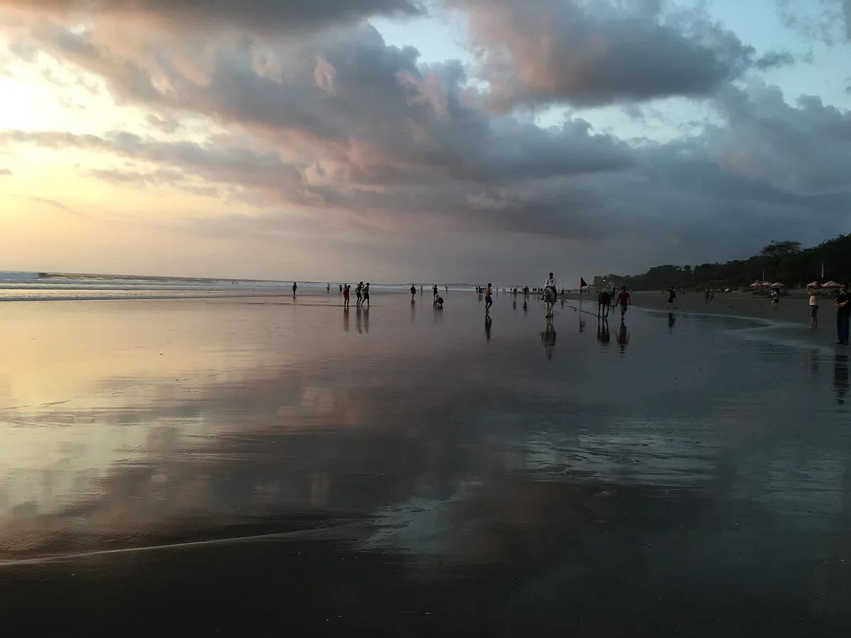 A beach with breaking waves under a bright sky